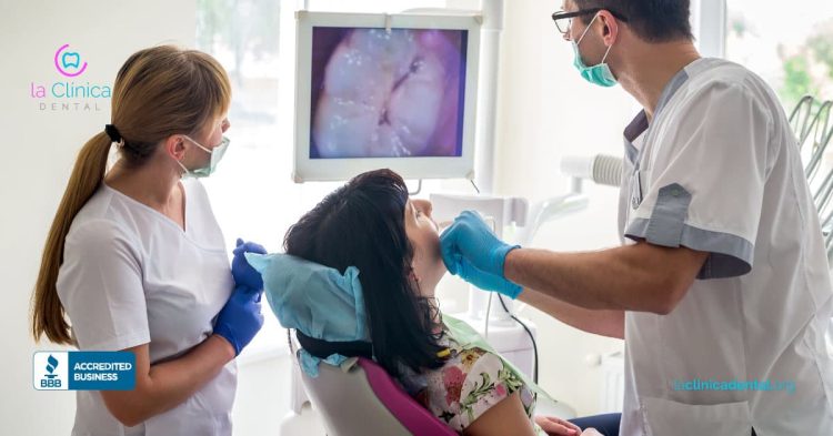 Médico dental examinando a paciente con cámara intraoral en La Clínica Dental, destacando tecnología avanzada para el cuidado dental.