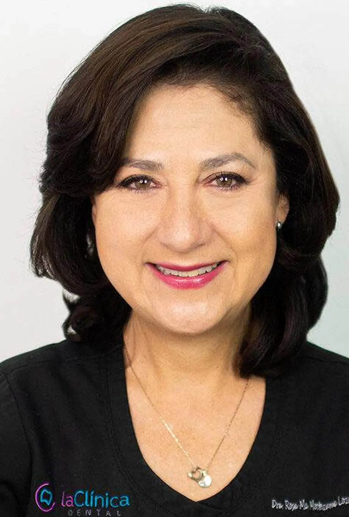 Dr. Rosa Ma. Moctezuma Lozano, dentist at La Clínica Dental, smiling in professional attire, showcasing expertise in dentistry and patient care.