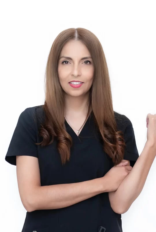 Dr. Rosa Ma. M., Director of La Clínica Dental, wearing a black medical uniform with long brown hair and a confident smile, promoting quality dental care.