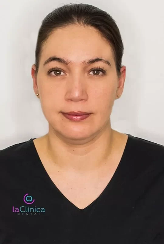 Dr. Pamela Socorro M., specialist in maxillofacial surgery at La Clínica Dental, wearing a black medical uniform with clinic logo.