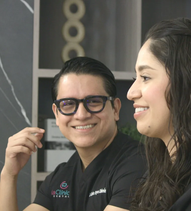 Dentist and patient smiling during consultation at La Clínica Dental Roma, showcasing friendly atmosphere and patient-centered care.