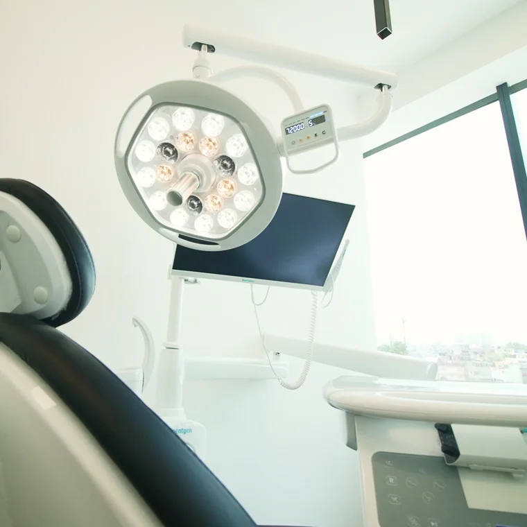 Dental treatment room featuring advanced surgical light and monitor, emphasizing La Clínica Dental Roma's commitment to state-of-the-art technology for corrective and aesthetic dental care.