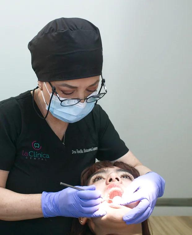 Dentist performing a dental examination on a patient at La Clínica Dental Roma, showcasing advanced dental care and patient-centered service.