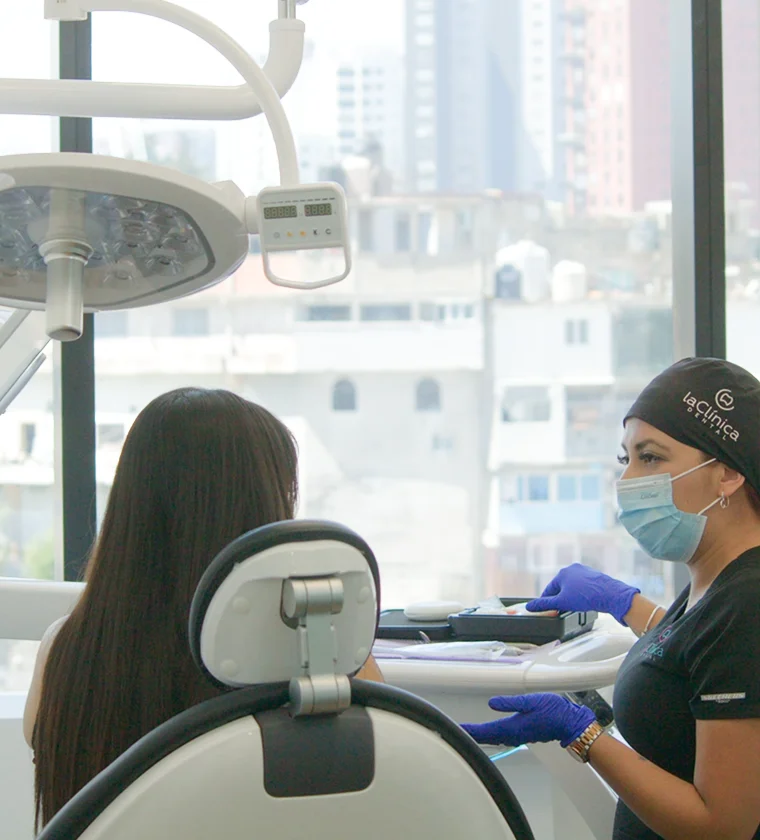 Dentist consulting with a patient in a modern dental clinic setting, emphasizing advanced technology and patient care at La Clínica Dental Roma.