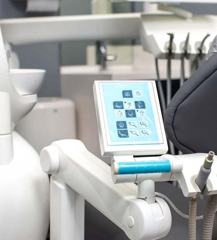 Dental chair control panel with touchscreen interface in a modern dental clinic setting, featuring icons for various dental procedures and equipment, highlighting advanced technology and patient comfort.