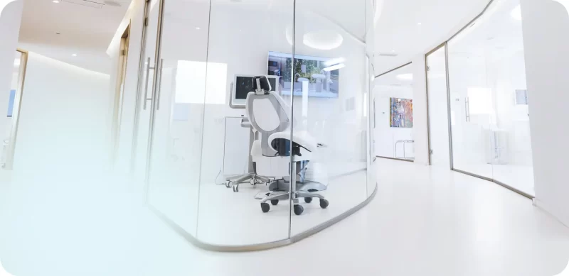 Consultorio dental moderno con silla de tratamiento y pantallas, enfatizando la importancia de un ambiente cómodo y profesional para superar el miedo a las visitas dentales.